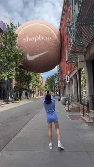 Tennis Ball Stuck Between Buildings in a fake-out-of-home ad of ShopBop