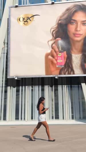 Hair Oil Sprays from Billboard in a fake-out-of-home ad of OGX Beauty