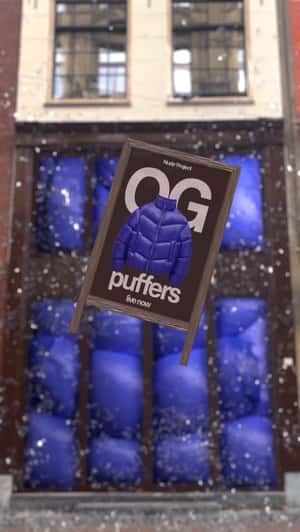 Giant Puffer Breaks Storefront Glass in a fake-out-of-home ad of Nude Project