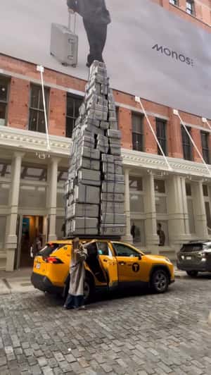 Towering Suitcase on Cab Roof in a fake-out-of-home ad of Monos