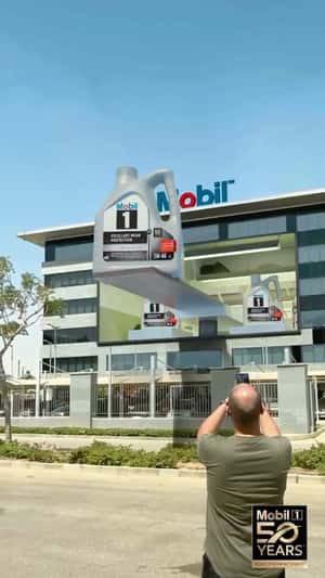 Building Facade Opens for Giant Oil Bottles in a fake-out-of-home ad of Mobil