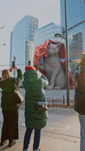 Giant Cat Sculpture Holding a Smartphone in a fake-out-of-home ad of Motorola
