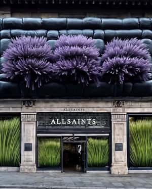 Purple Flowers Pop Out of Facade in a fake-out-of-home ad of AllSaints