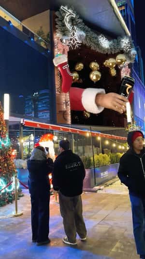 Santa's Hand with Can Pops Out of Billboard in a fake-out-of-home ad of Saber Energy