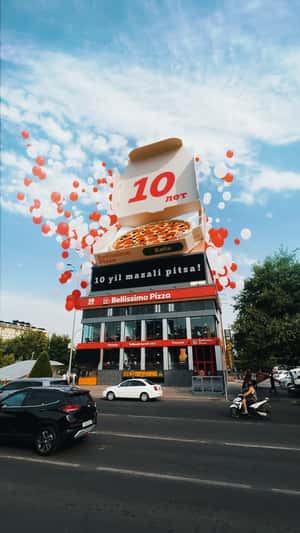 Giant Pizza Atop Store in a fake-out-of-home ad of Bellissimo Pizza 