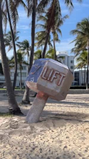 Giant Dumbbell on Sand in a fake-out-of-home ad of Gymshark