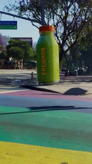 Giant Bottle at Rainbow Crosswalk in a fake-out-of-home ad of Erewhon