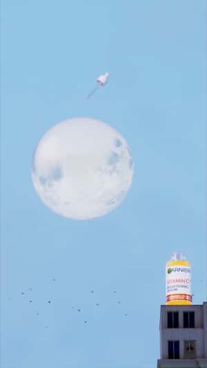 Giant Serum Illuminates Full Moon in a fake-out-of-home ad of Garnier