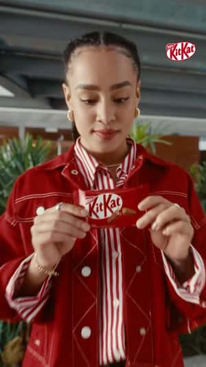 Woman Runs Away from Hovering Notifications in a fake-out-of-home ad of KitKat