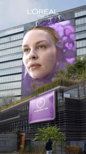 Woman's Face Emerges from Facade in a fake-out-of-home ad of L'Oréal Paris