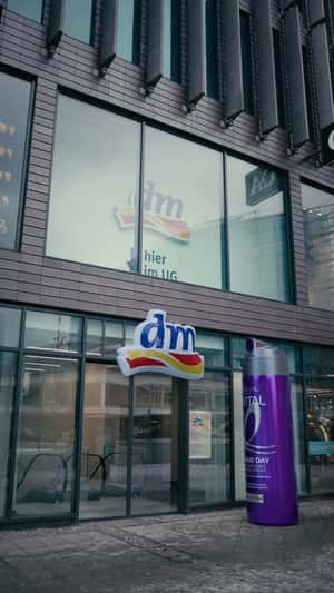 Giant Spray Inflates DM Store Logo in a fake-out-of-home ad of L'Oréal Paris