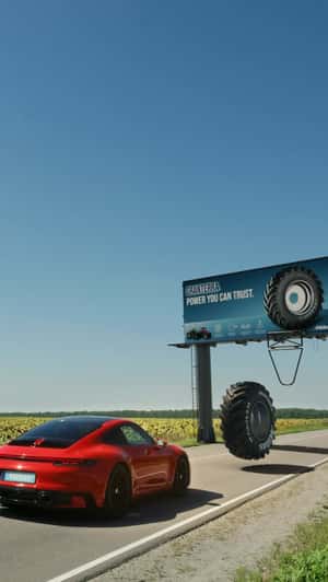 Giant Tire Passes Over Sports Car in a fake-out-of-home ad of Mitas Agri Tires