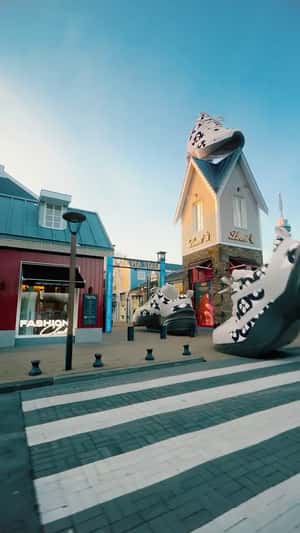 Giant Sneakers March Through Outlet in a fake-out-of-home ad of Batavia Stad Fashion Outlet