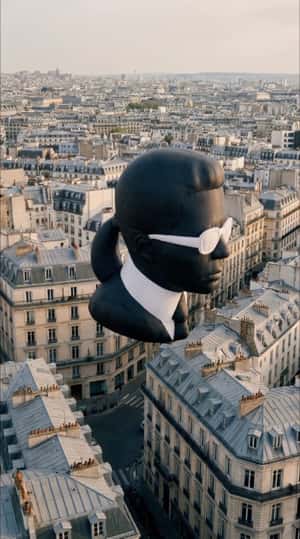 Head Sculpture Floats Over Paris in a fake-out-of-home ad of Karl Lagerfeld