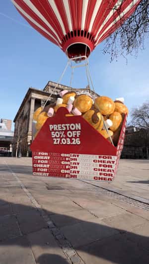 Hot Air Balloon Drops Giant Waffle Box in a fake-out-of-home ad of Cheat Daze
