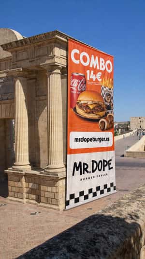 Giant Banner Unfolds on Building in a fake-out-of-home ad of Mr. Dope