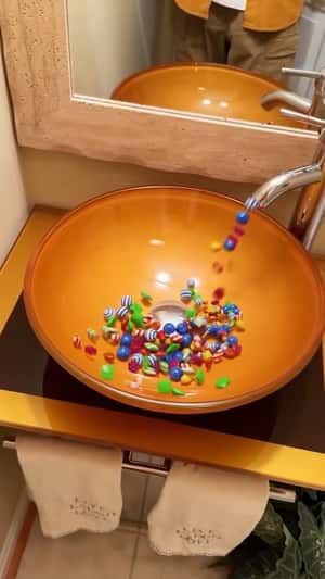 Candies Pour Out of Faucet in a fake-out-of-home ad of Candy Crush