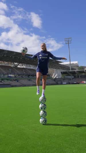 Woman Balances on Stacked Footballs in a fake-out-of-home ad of Veikkaus