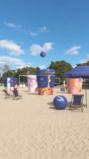 Giant Ice Cream Tubs Play Beach Volleyball in a fake-out-of-home ad of Fazer