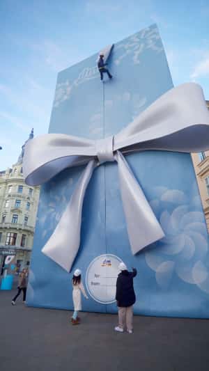 Giant Gift Box Stands on Street Corner in a fake-out-of-home ad of DM