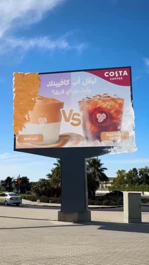 Giant Coffees Burst Out of Billboard in a fake-out-of-home ad of Costa Coffee