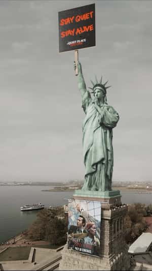 Showcasing a haunting display, this Paramount Pictures Statue Holding Placard CGI features the Statue of Liberty becomes part of a gripping scene for “A Quiet Place: Day One.” Holding a placard with the ominous words “STAY QUIET STAY ALIVE,” the Statue lifts her arm to her lips, signaling a shush gesture. At the same time, a massive movie poster unfurls down her platform. This stunning CGI campaign transforms the iconic landmark into a symbol of suspense, drawing audiences into the world of the film with an unforgettable display of creativity and CGI marketing innovation.