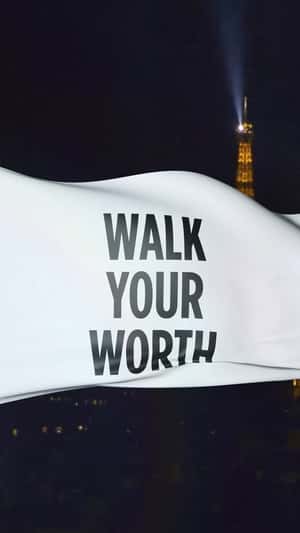 “WALK YOUR WORTH”  banner on Eiffel Tower fake-out-of-home ad of L'Oréal Paris