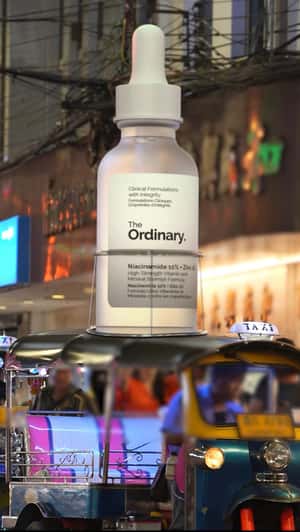 Bottle Rides Tuk Tuk of Thailand in a fake-out-of-home ad of The Ordinary