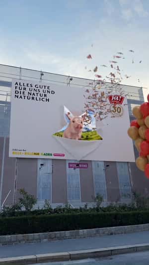 Pig Sneaks Out From Billboard in fake-out-of-home ad of Ja Natürlich