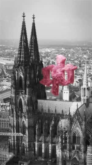 Pink fuzzy logo above Cologne Cathedral in fake-out-of-home ad of A Quick Buck