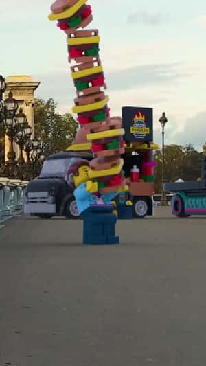 Minifigure Balances Burger Stack in fake-out-of-home ad of LEGO