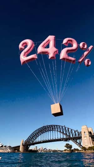 Pink Number Balloons Float Above the Bridge in a fake-out-of-home ad of Benefit Cosmetics