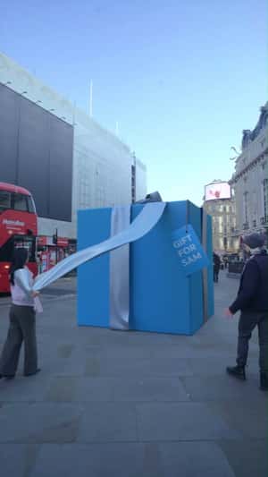 Blue Gift Box Unveiled in the Street in fake-out-of-home promotional ad of Honor