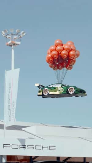 Porsche 911 GT3 RS carried by balloons a fake-out-of-home ad of Porsche