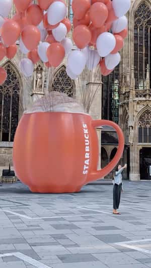 Pink Mug on Balloons Arrives at Church in fake-out-of-home ad of Starbucks