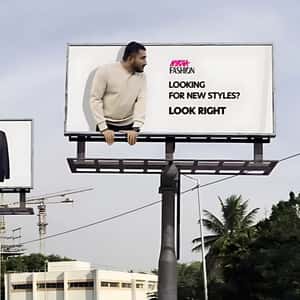 Man Crossing Through Billboards in a fake-out-of-home ad of Nykaa Fashion