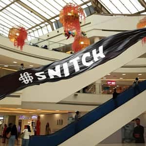 Black Banner Flying Above Buildings in a fake-out-of-home ad of Snitch