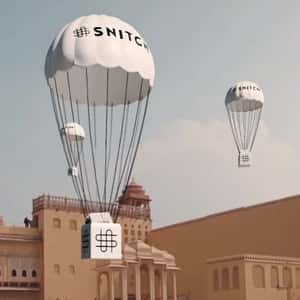 Parachutes Pull Off Red Cloth of Store in a fake-out-of-home ad of Snitch