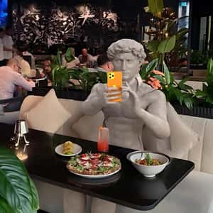 Marble Statue Taking Photo in a fake-out-of-home ad of Amaya