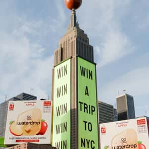 Package on Parachute and Raining Apples in a fake-out-of-home ad of Waterdrop