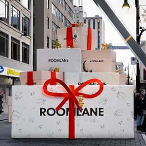 Crane Truck Unwrapps Gift Box in a fake-out-of-home ad of Room Lane