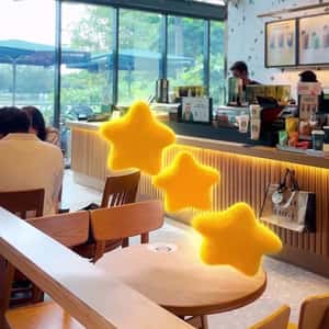 Glowing Plushie Stars Bouncing in a fake-out-of-home ad of Starbucks