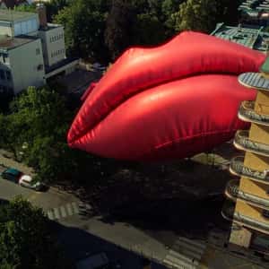Inflatable Red Lips Installed on Buildings in a fake-out-of-home ad of Smile
