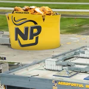 Noodle Bowl Stands on Airport Runway in a fake-out-of-home ad of Noodle Pack