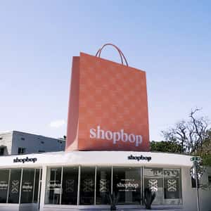 Pink Helicopter Carries Shopping Bag in a fake-out-of-home ad of Shopbop