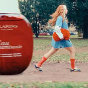 Woman Playing with Beauty Products in a fake-out-of-home ad of Clarins