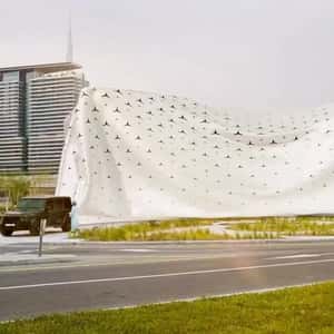 Car Pulls Cloth to Unveil Building in a fake-out-of-home ad of Mercedes-Benz