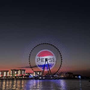 Logo Display at Ferris Wheel Light Show in a fake-out-of-home ad of Pepsi