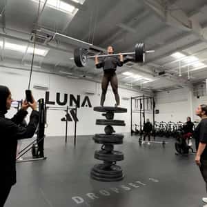 Woman Balancing on Piled Weight Plates in a fake-out-of-home ad of Adidas
