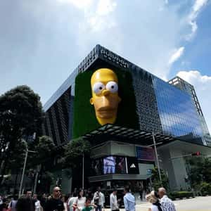 Yellow Hand Shows Sneaker at Facade in a fake-out-of-home ad of Adidas